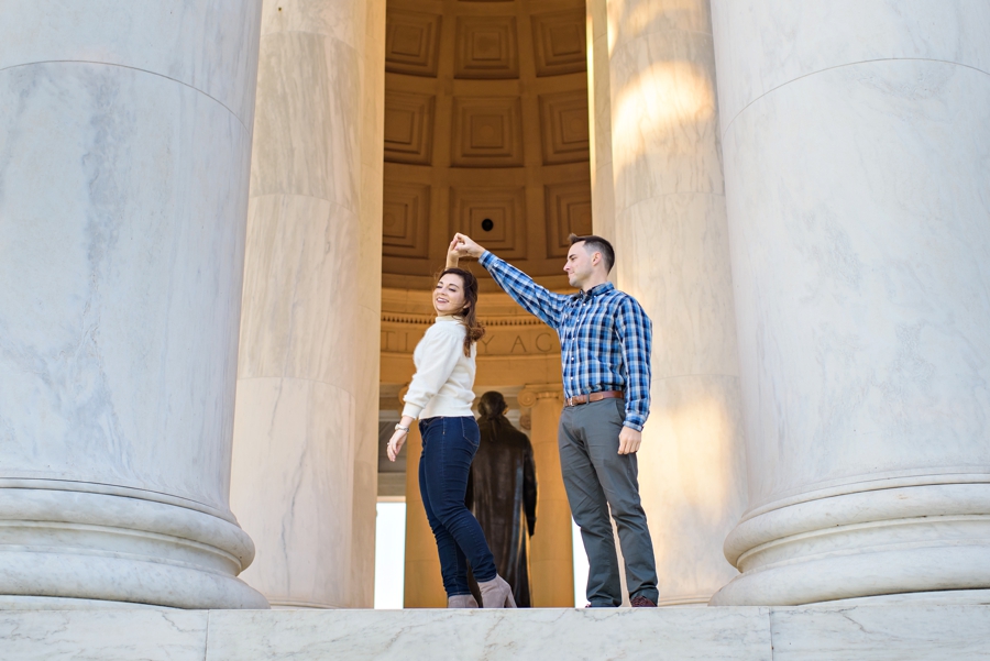 A man spins his bride to be on the steps of the Lincoln Memorial.